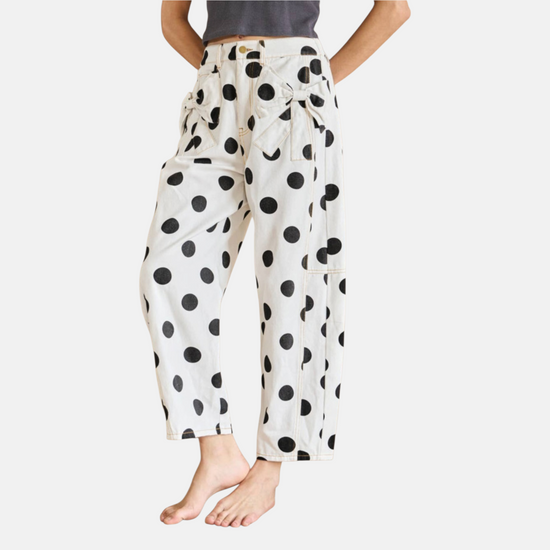 Front lifestyle view of the white polka dot wide-leg jeans featuring a structured waist and feminine bow accents.