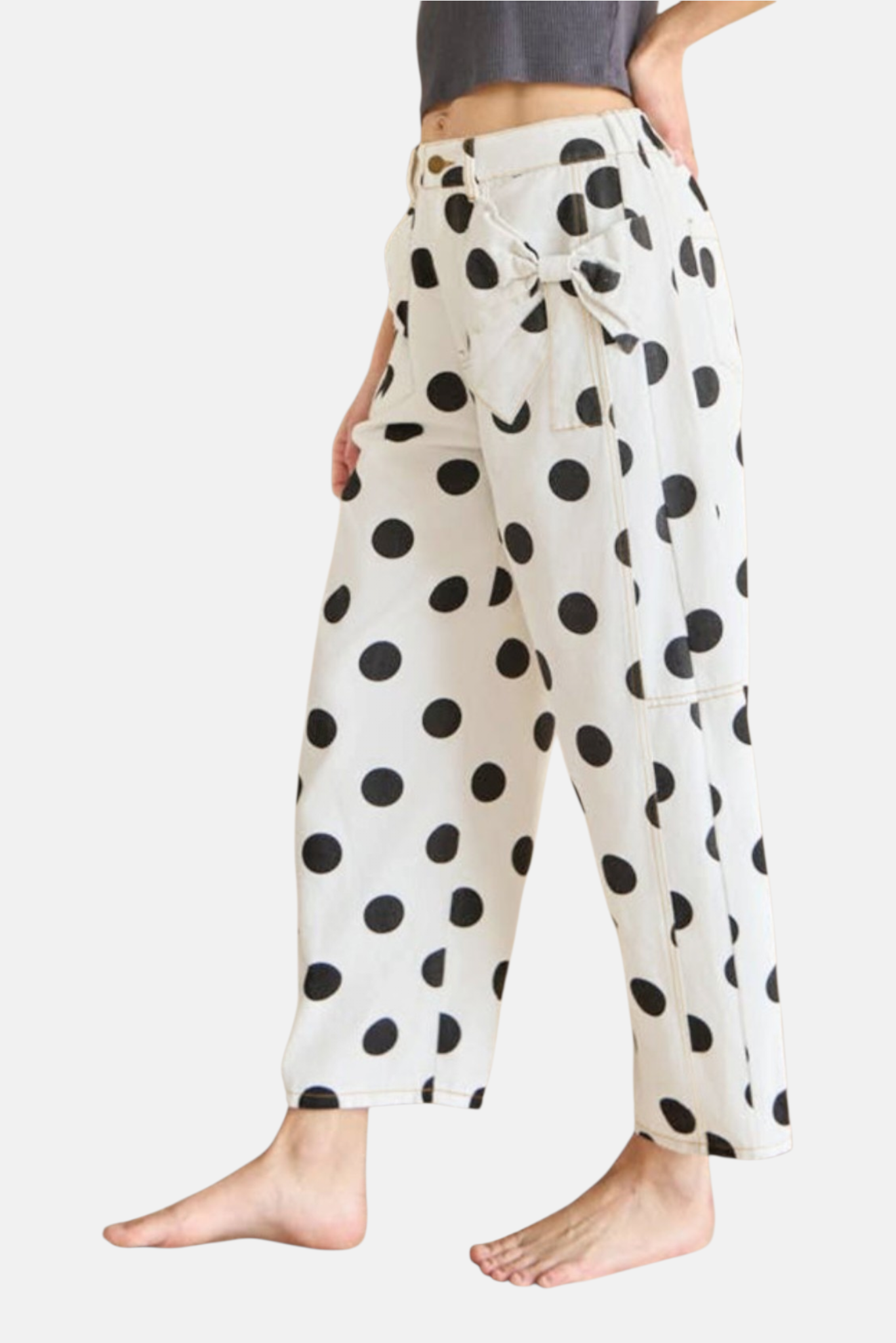 White pants with black polka dots worn by a person on a white background