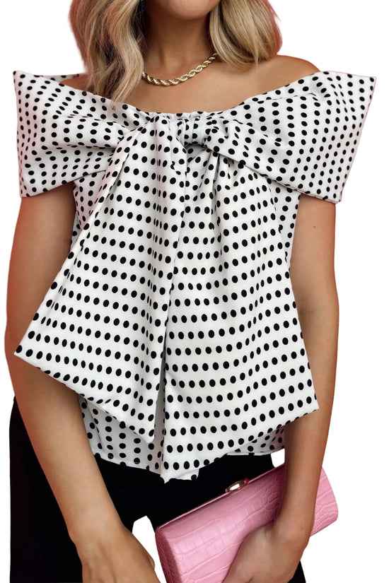Woman wearing a polka dot off-shoulder top with a white background