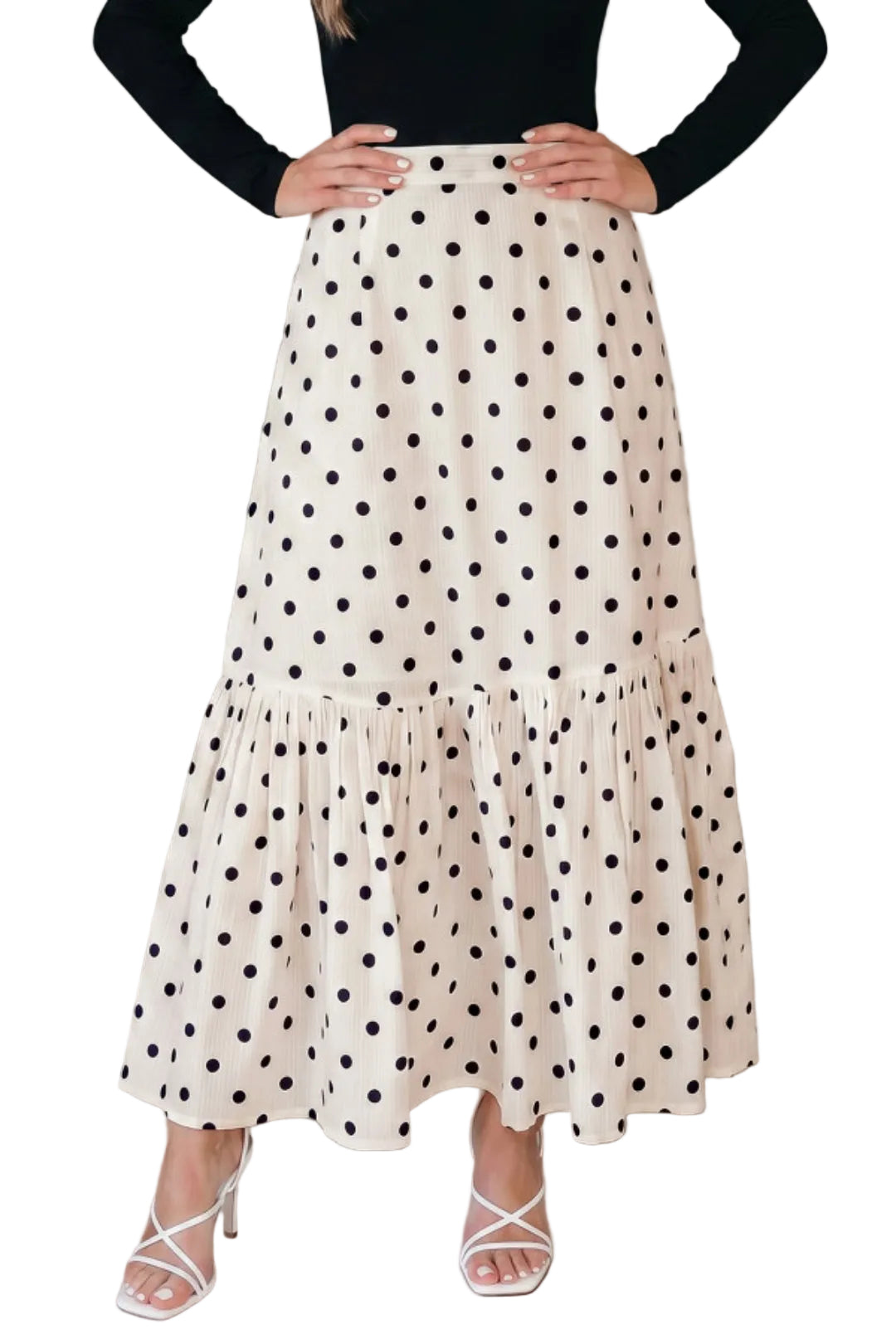 Woman wearing a polka dot skirt with a plain background