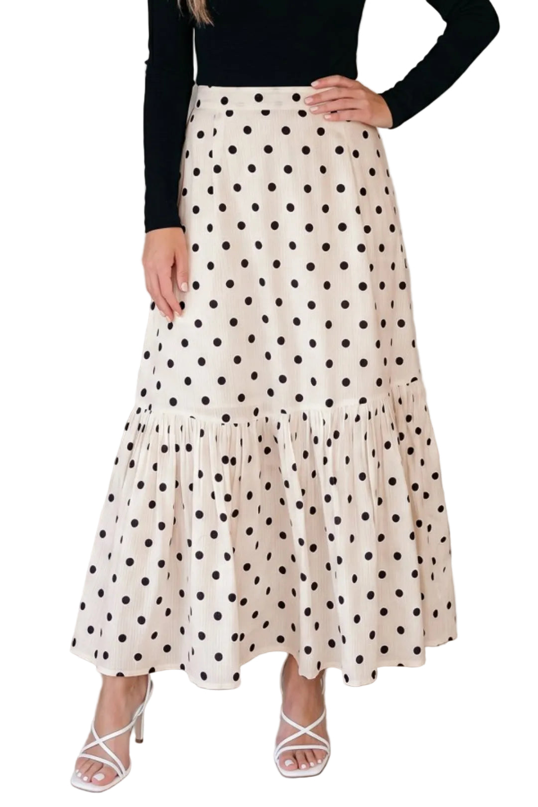 Woman wearing a polka dot skirt with a plain background