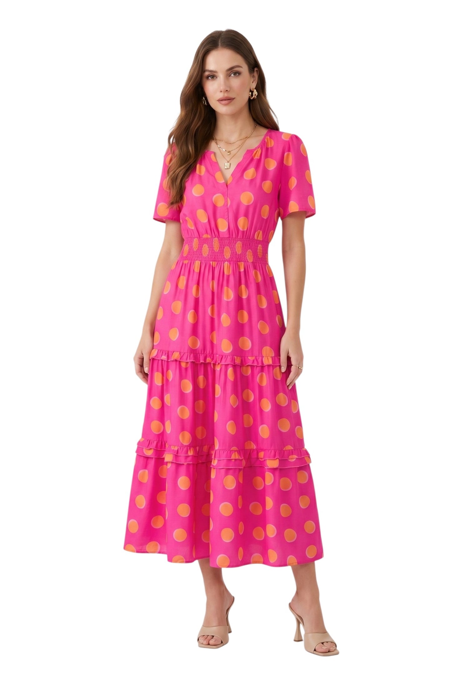 Woman wearing a pink dress with yellow polka dots on a white background