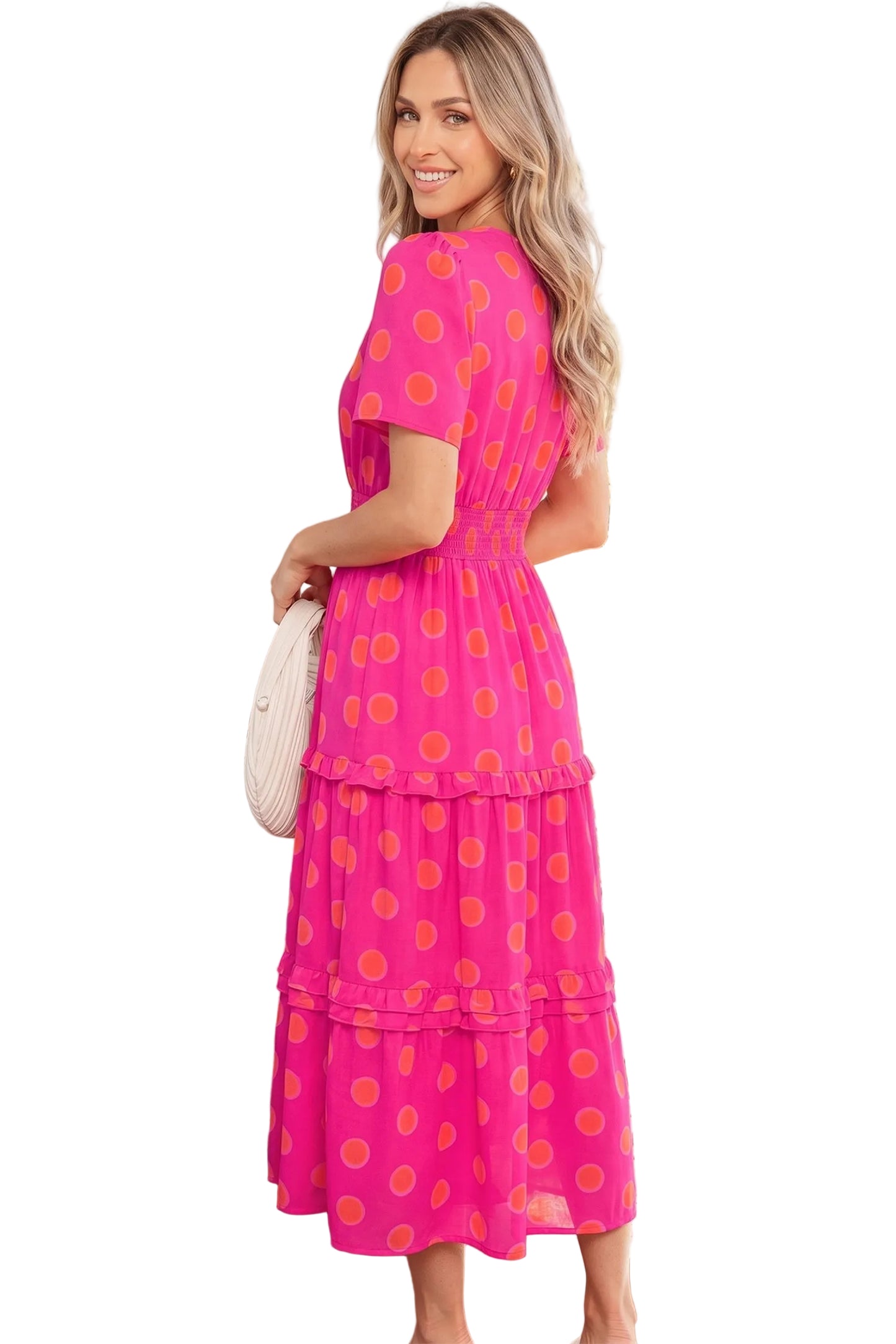 Woman wearing a pink dress with orange polka dots on a white background