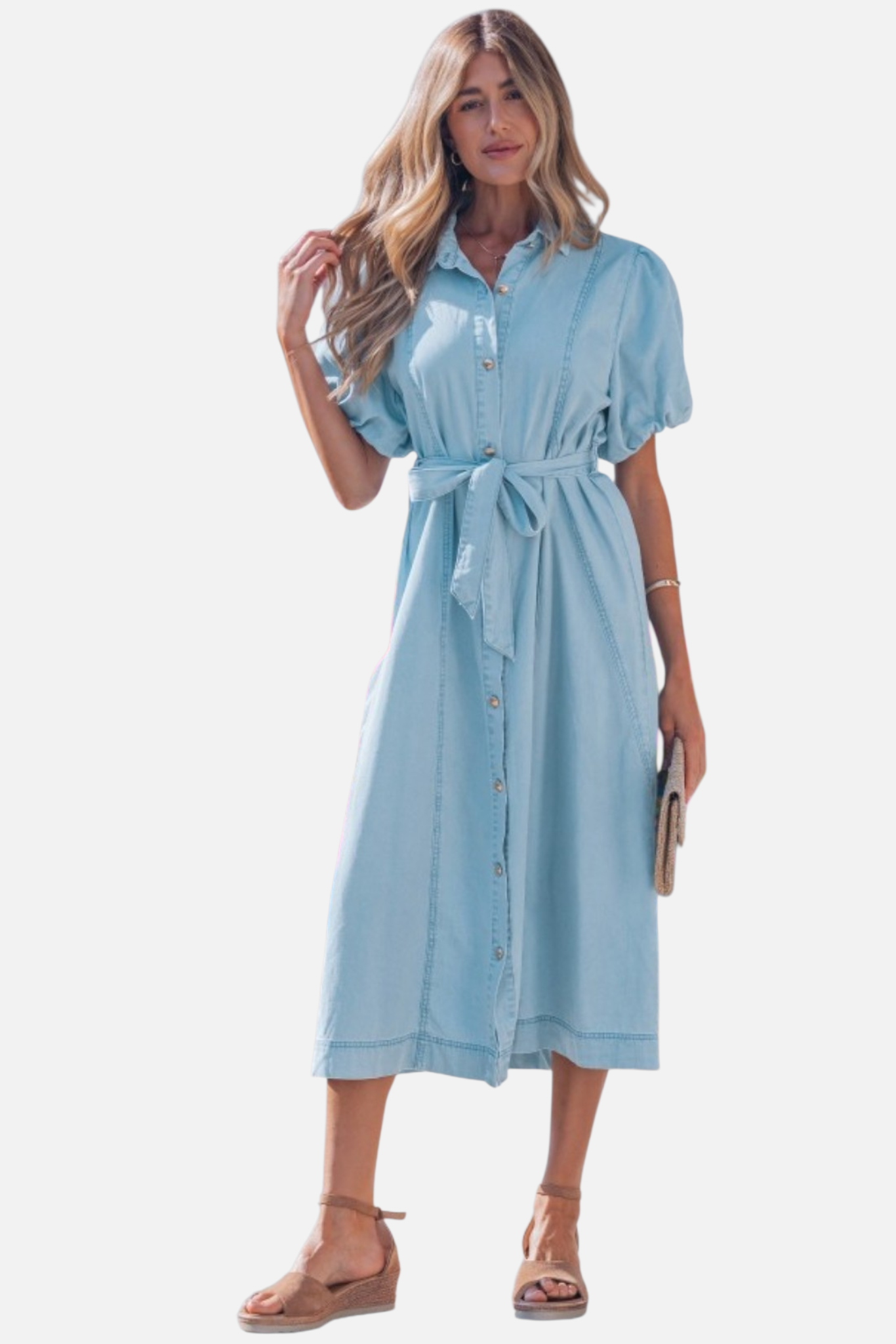 Front view of a model in a light blue denim shirt dress featuring voluminous puff sleeves and a self-tie bow at the waist.