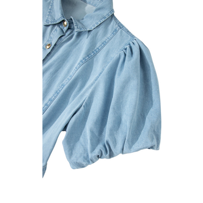 Detailed view of the voluminous elasticated puff sleeve on the light blue cotton denim dress, highlighting the soft fabric texture.