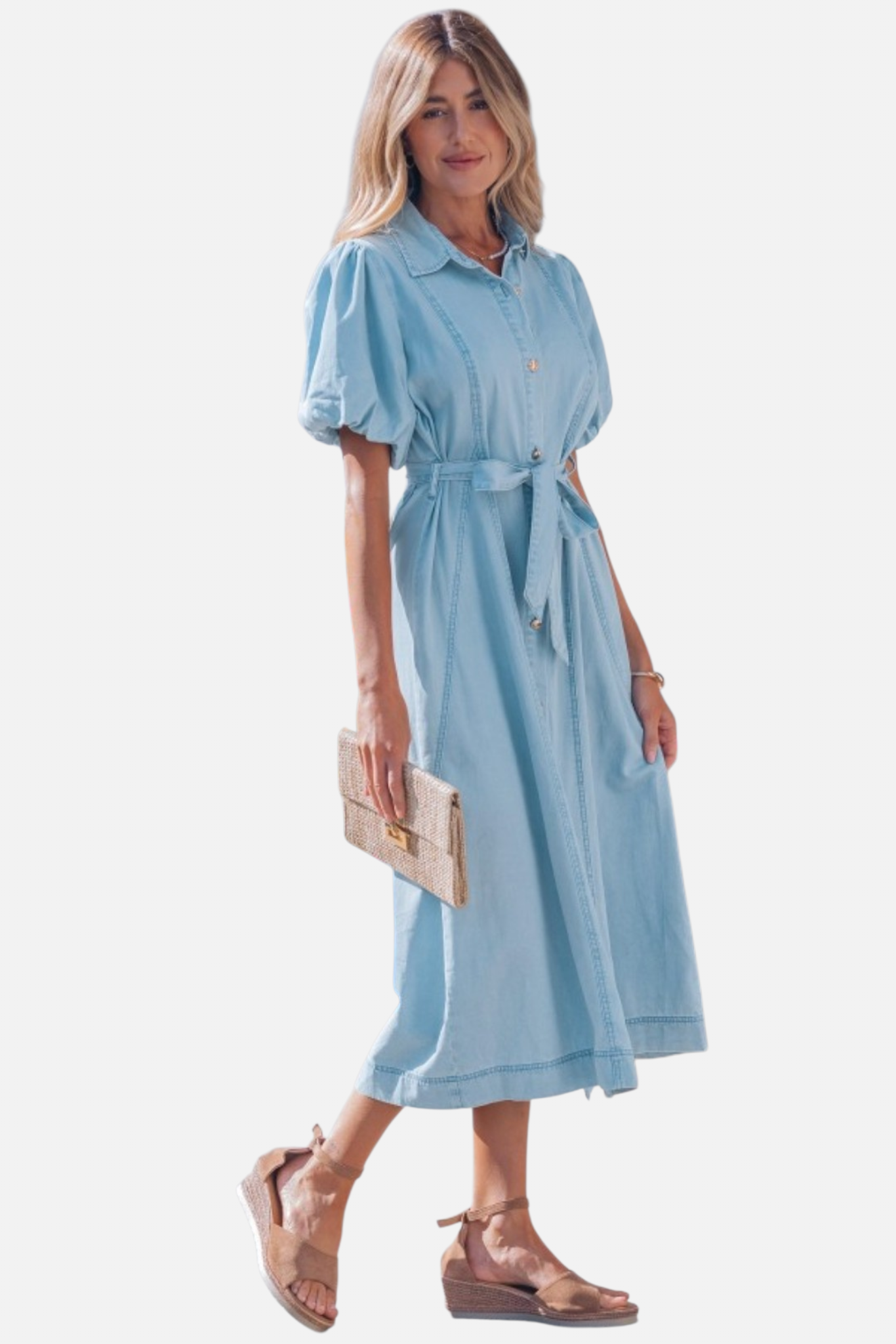 Front view of a model in a light blue denim shirt dress featuring voluminous puff sleeves and a self-tie bow at the waist.