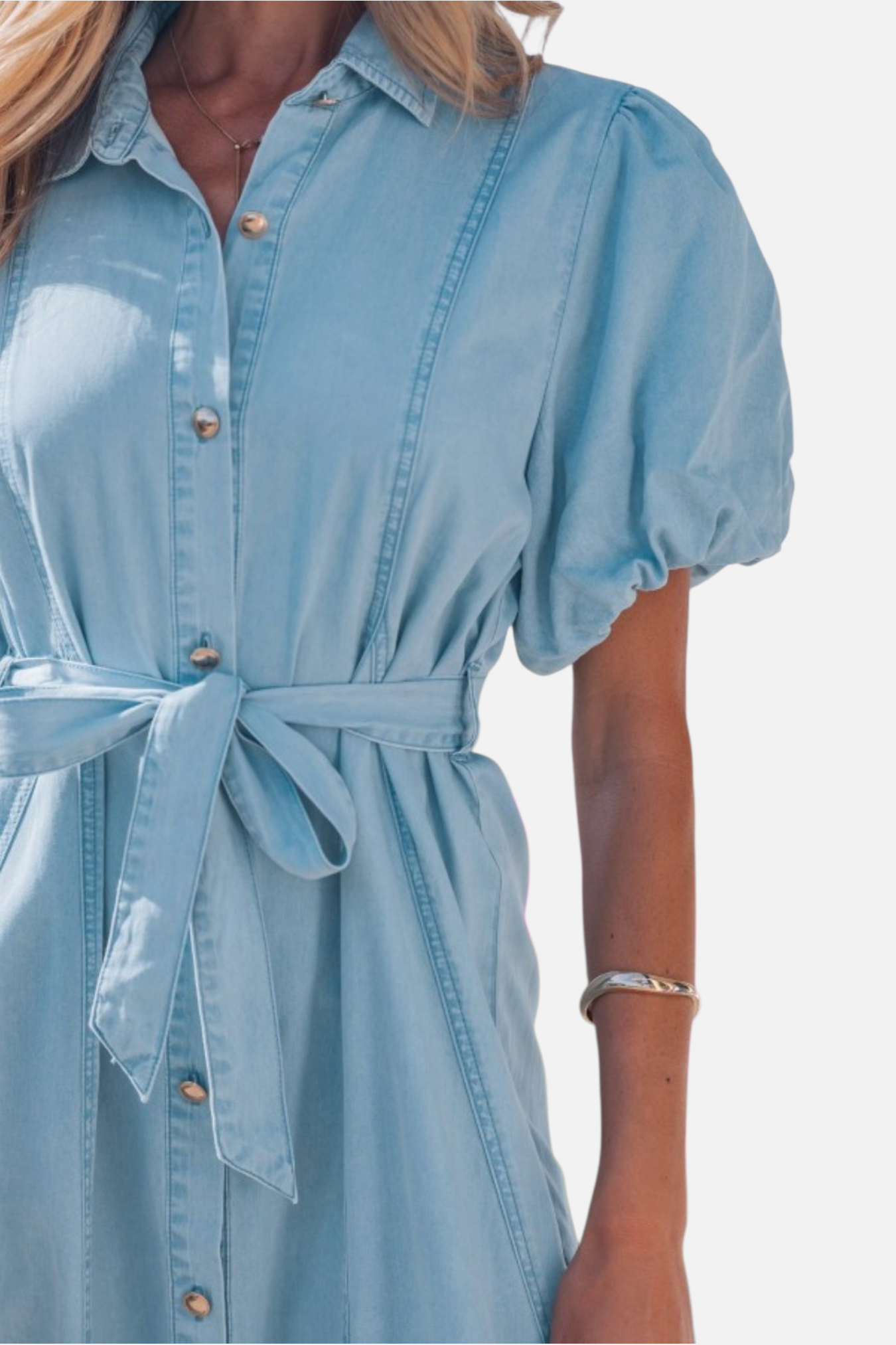Light blue denim dress with a belt on a white background