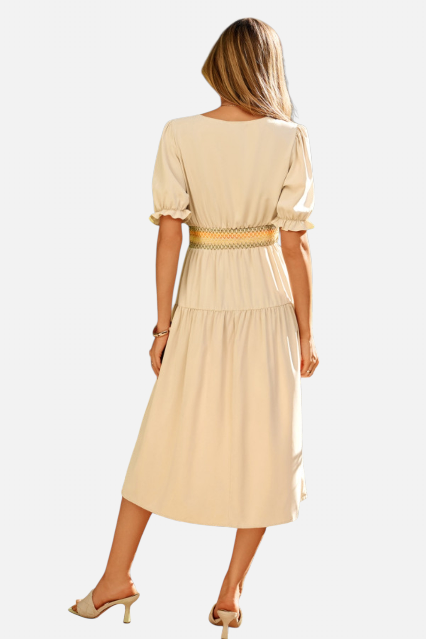 Woman wearing a beige dress with a belt on a white background
