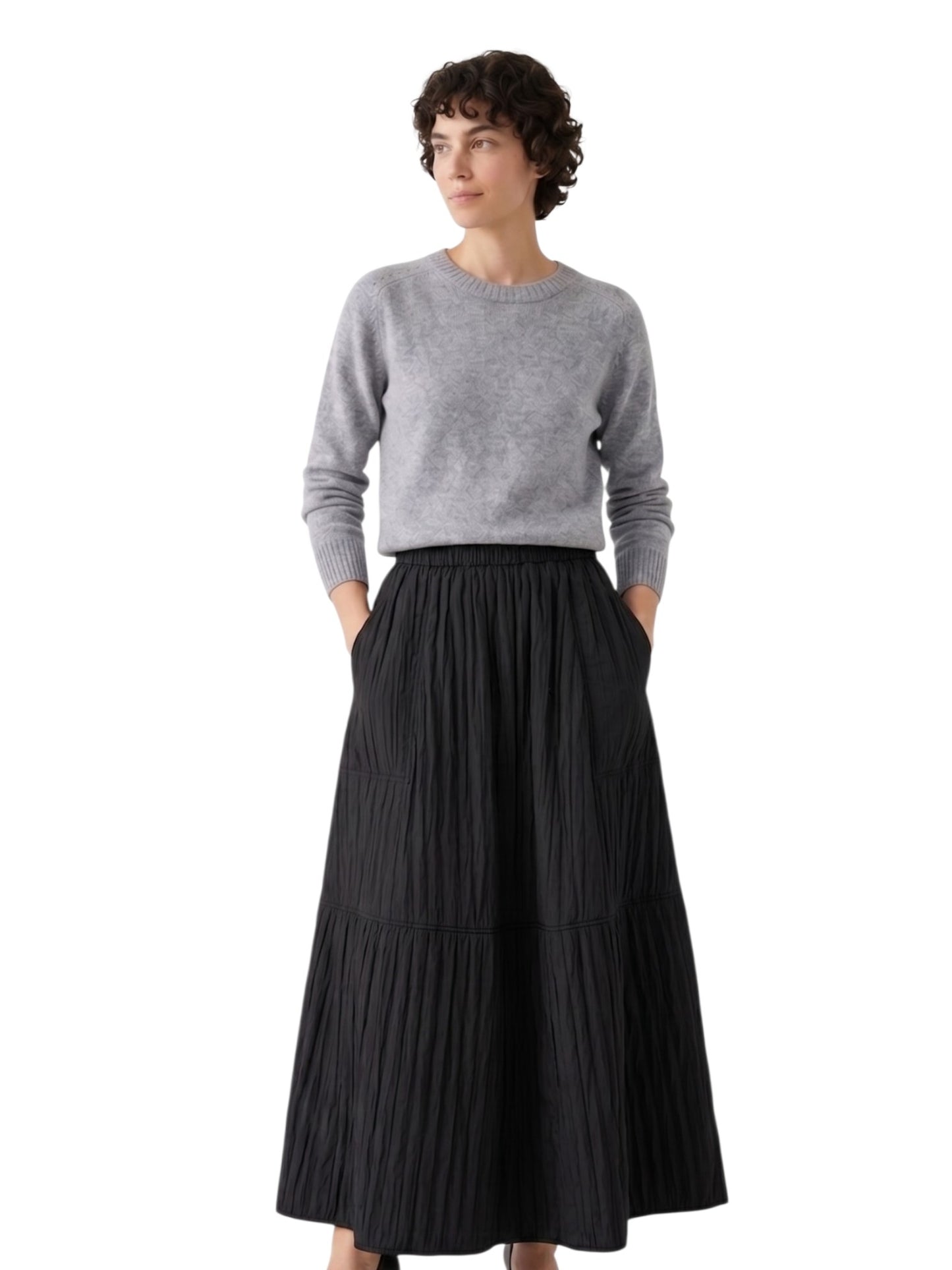 Woman wearing a gray sweater and black pleated skirt on a white background