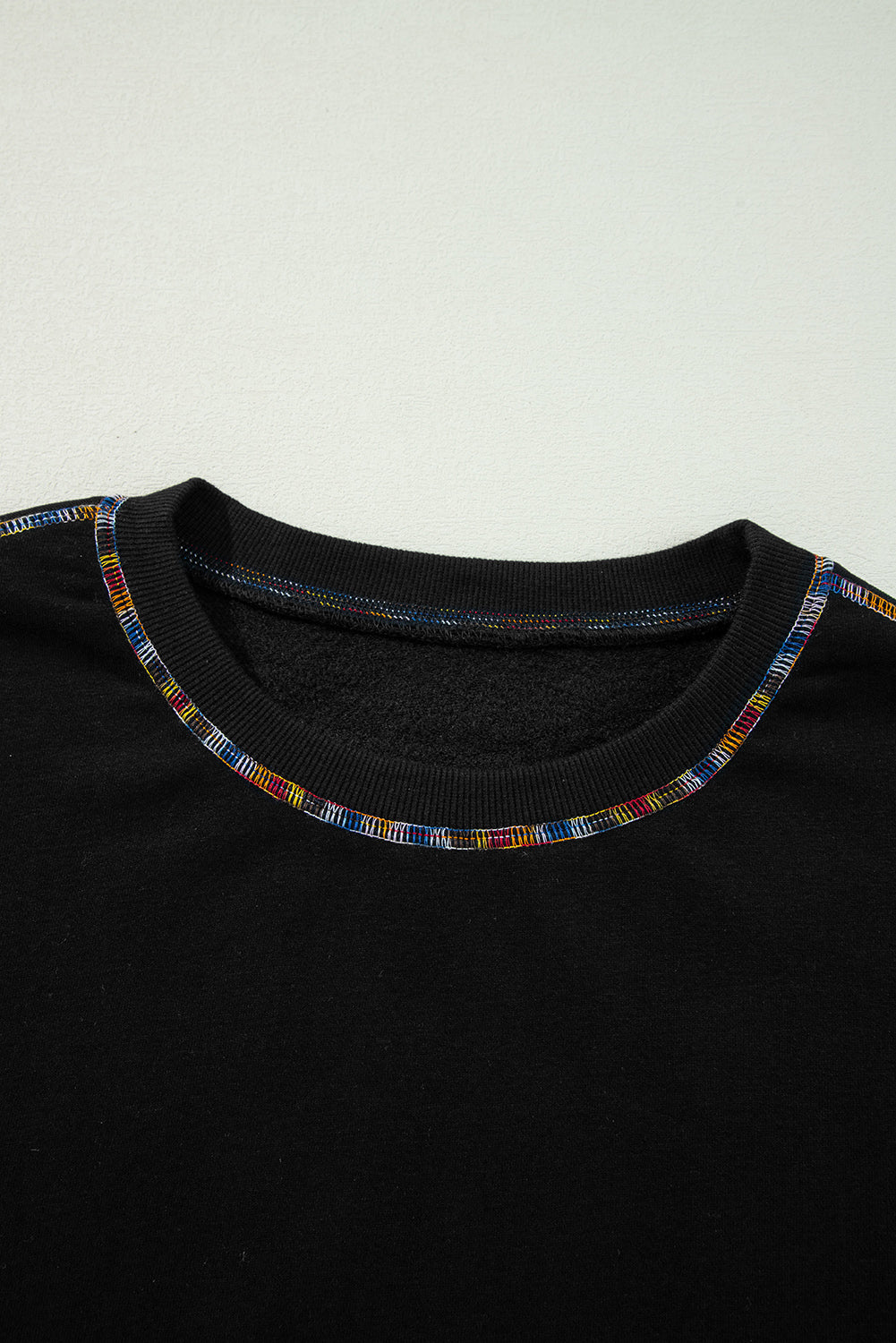 Black top with colorful trim on a white background