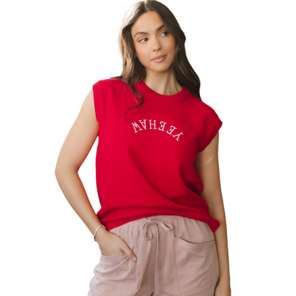 Model wearing a vibrant red sleeveless knit vest with white "YEEHAW" embroidery in a western font across the chest.