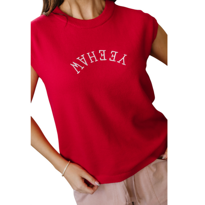 Model wearing a vibrant red sleeveless knit vest with white "YEEHAW" embroidery in a western font across the chest.