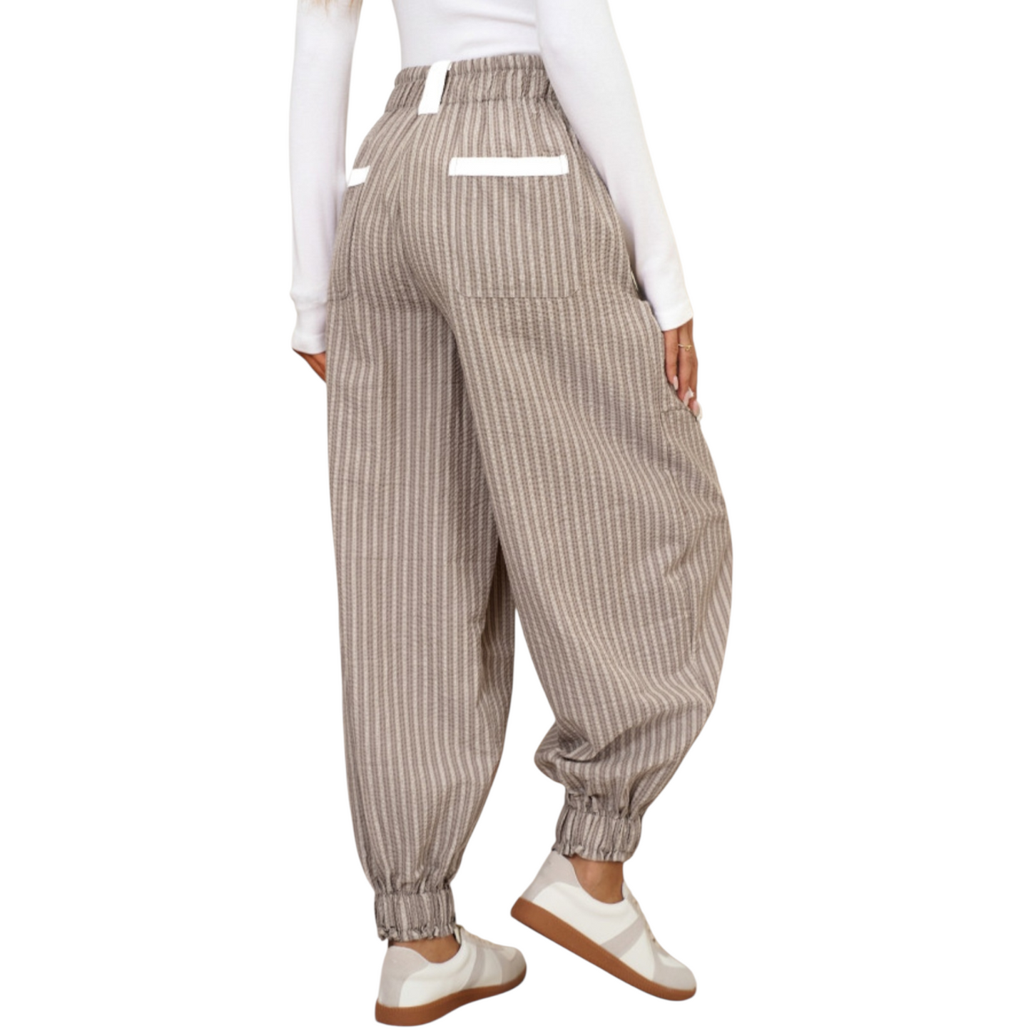 Person wearing beige striped pants and white shoes on a white background