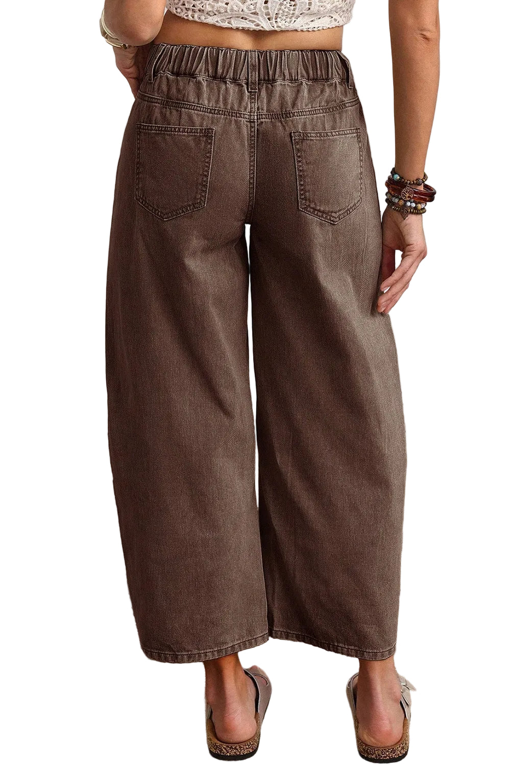 Rear view highlighting the gathered elastic back waistband and square pockets on the washed brown jeans.