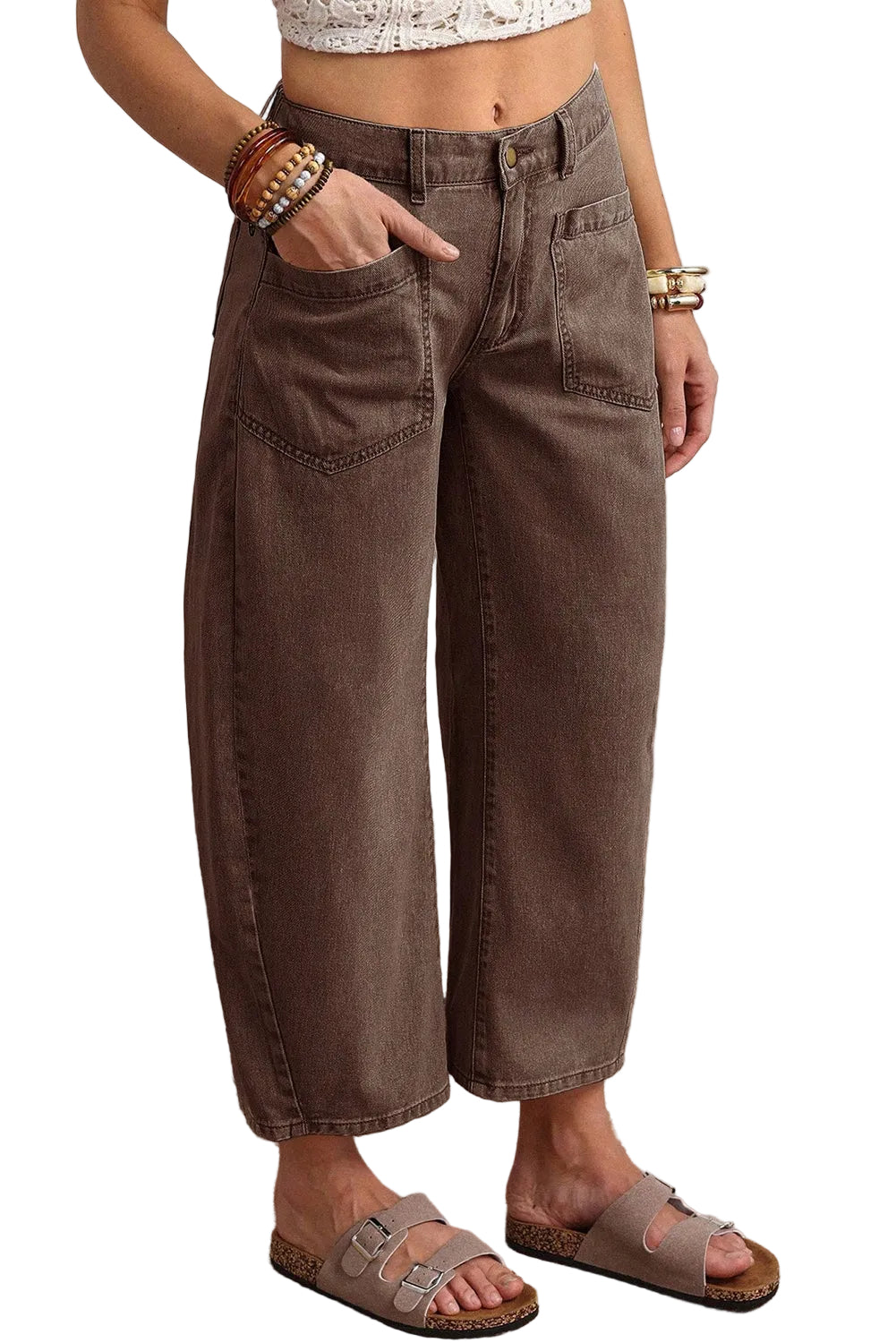 Person wearing brown wide-leg jeans with a white background