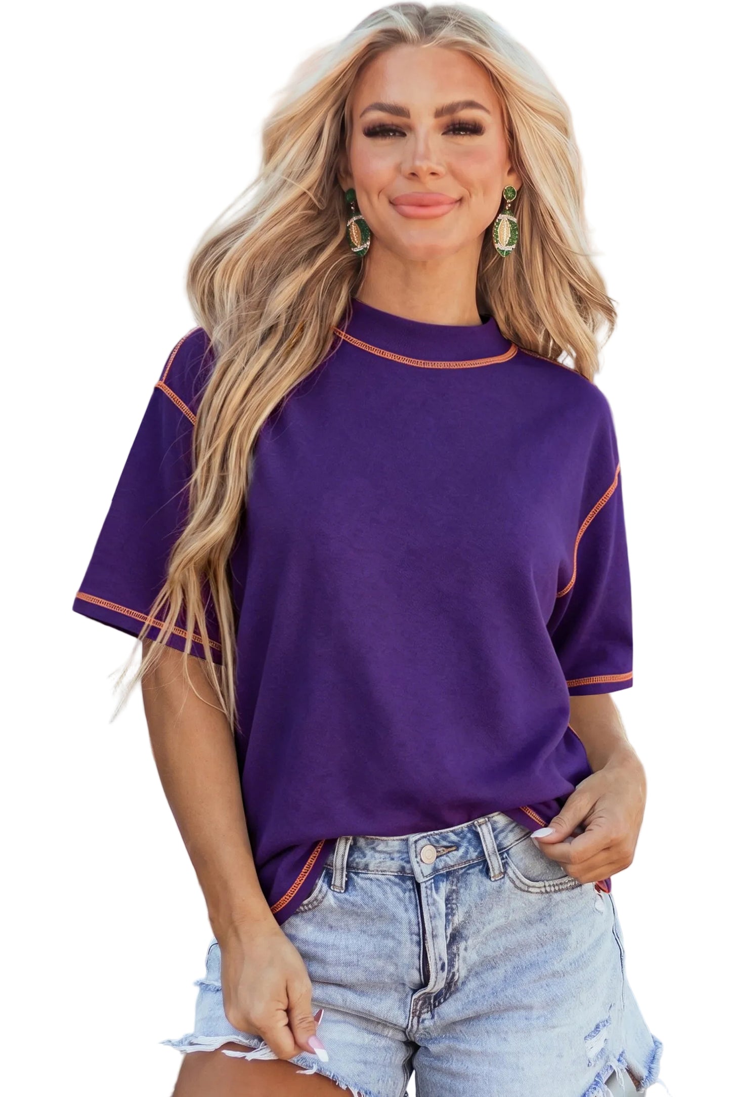 Model wearing a purple mock neck oversized t-shirt featuring bright orange contrast stitching along the seams and dropped shoulders.