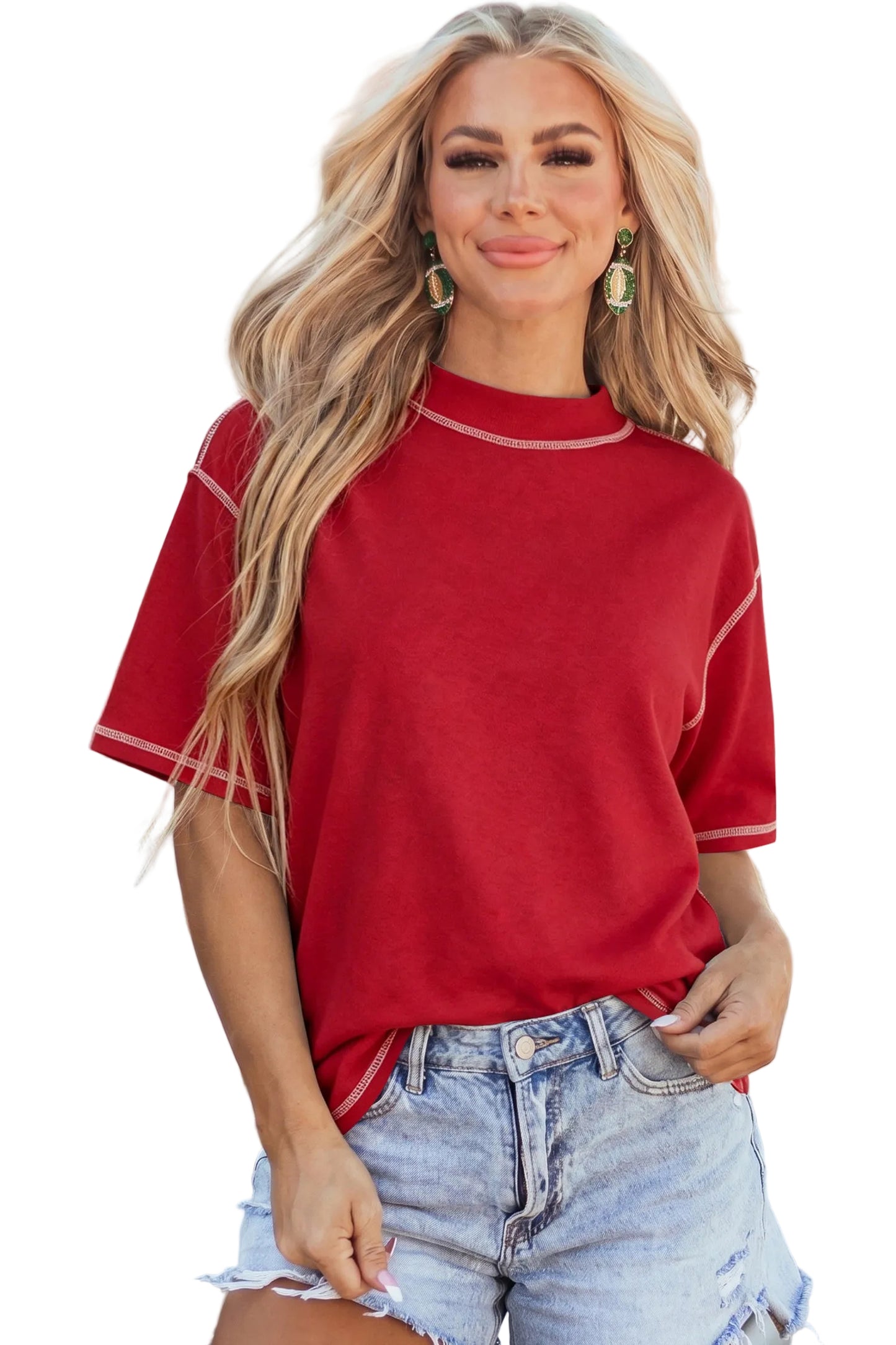 Model wearing a crimson red drop-shoulder basic tee with white structural exposed contrast stitching paired with light denim shorts.
