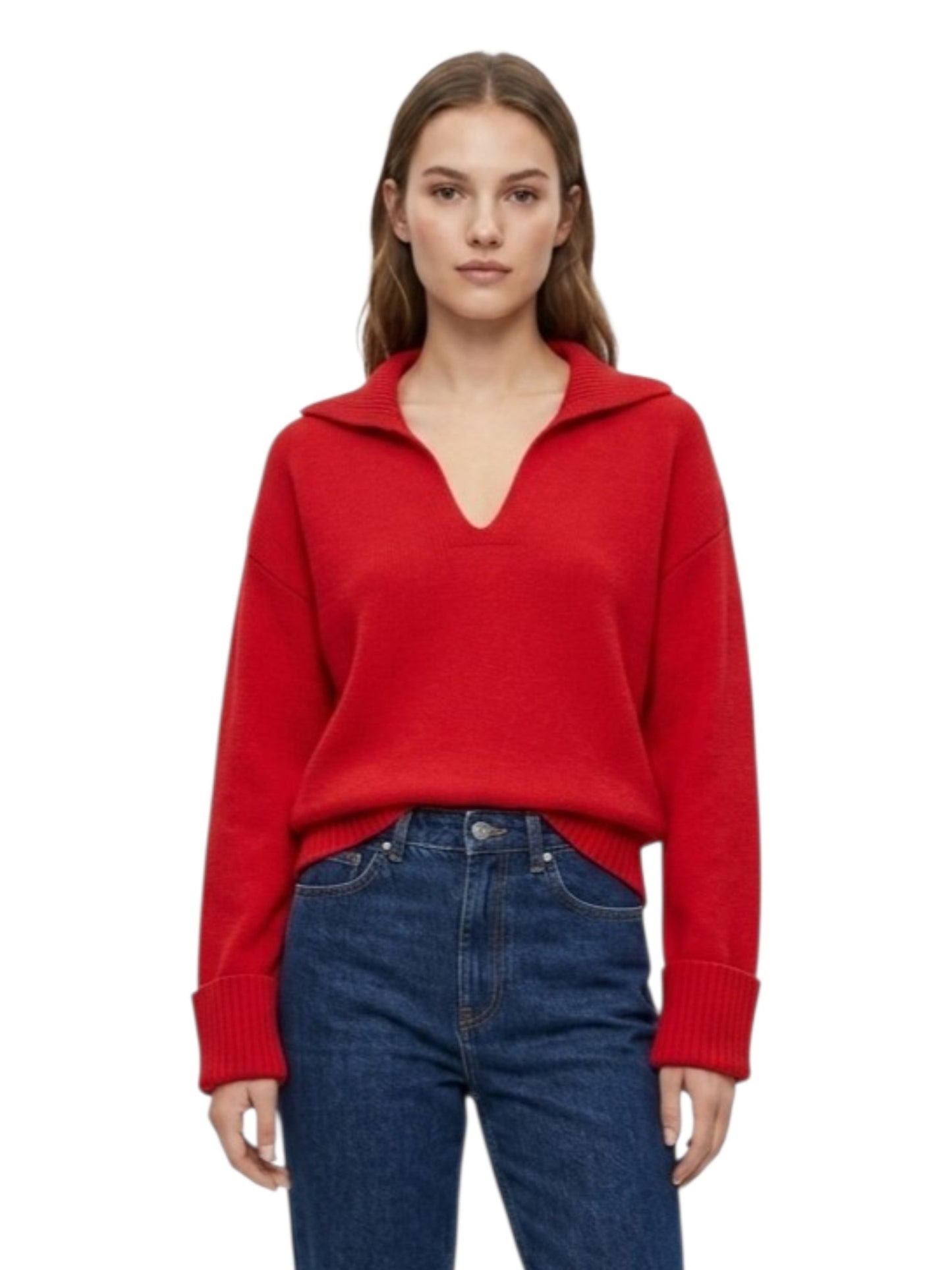 A woman wearing a bright red knit sweater with a half-zip or split collar and dark blue jeans, photographed against a plain white studio background.