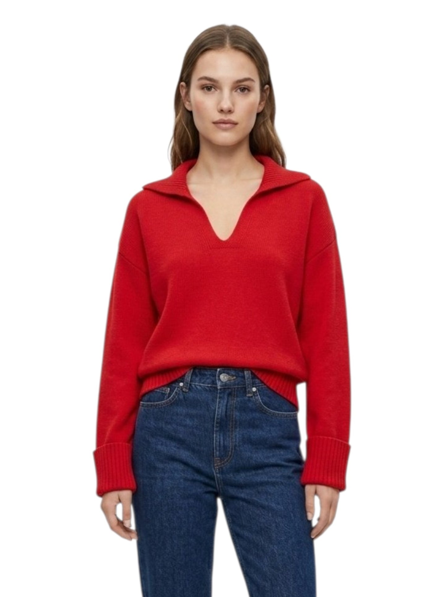 A woman modeling a bright red knit sweater with a short mock neck and blue jeans against a plain white background.
