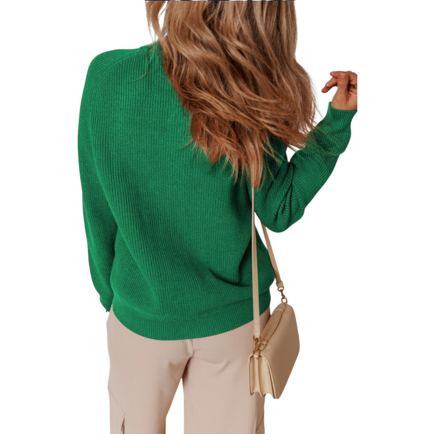 Person wearing a green sweater and beige pants with a beige handbag on a white background