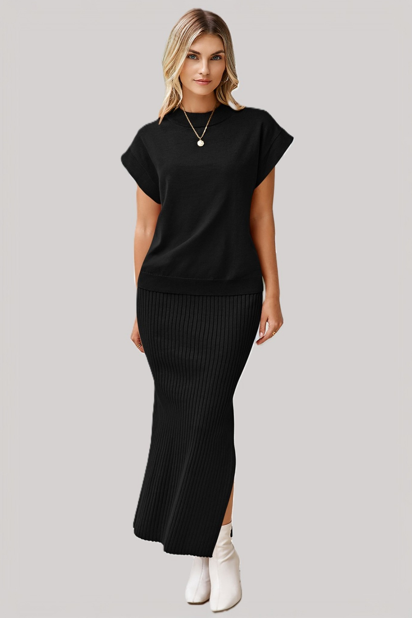 A model wearing a solid black two-piece set featuring a relaxed-fit dolman-sleeve tee and a matching ribbed midi skirt with a side slit.