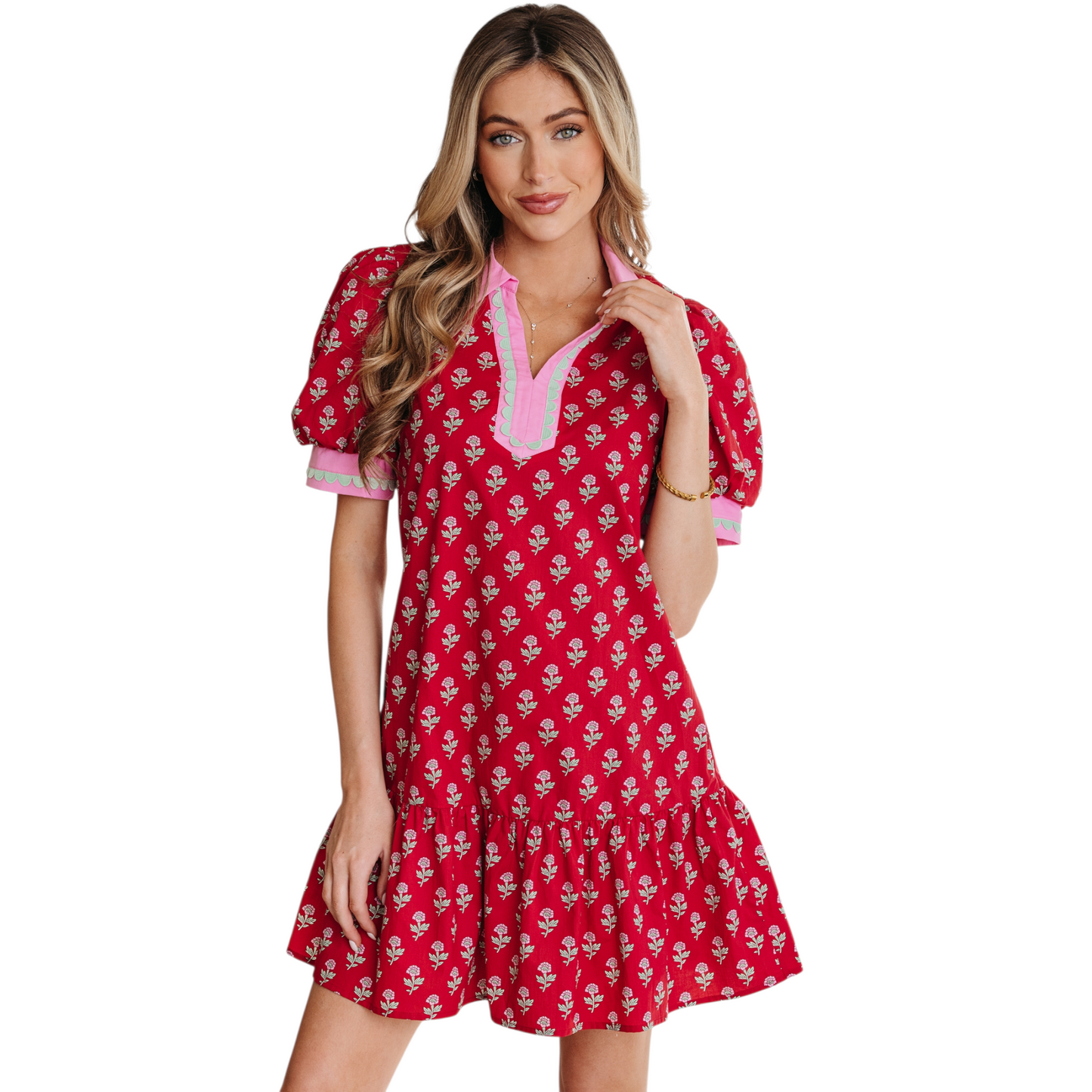 Woman wearing a red floral cotton mini dress with pink ricrac trim, V-neckline, and puff sleeves.