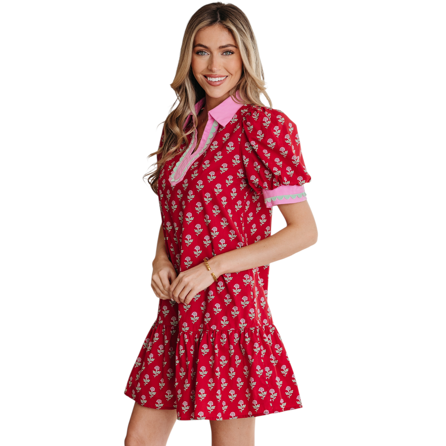 Woman wearing a red floral cotton mini dress with pink ricrac trim, V-neckline, and puff sleeves.