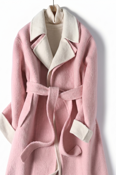 Front view of a dusty rose pink wool wrap coat featuring a cream-colored notched lapel and matching self-tie waist belt.