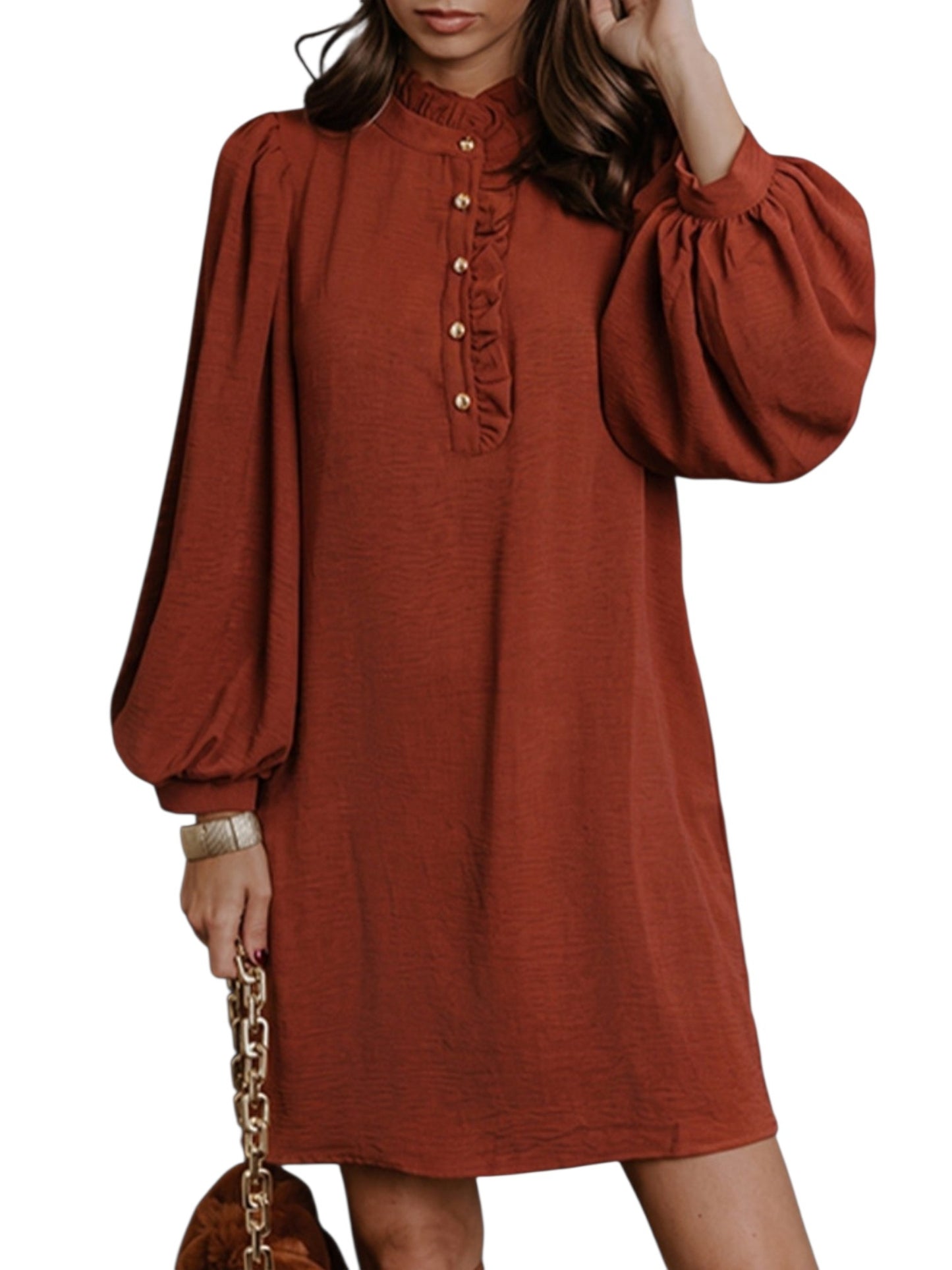 A woman wearing a rust-orange long-sleeve dress with a ruffled high neckline and decorative buttons down the front, shown against a plain white background.