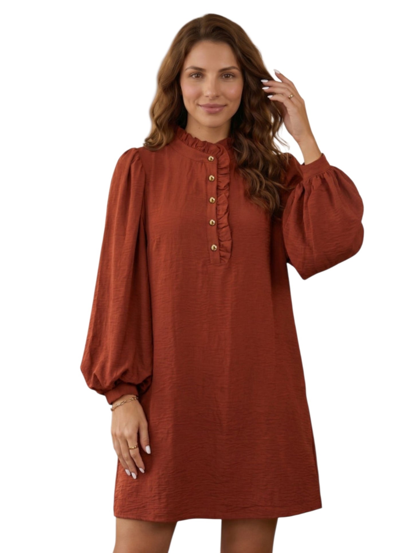 A woman modeling a rust-colored, long-sleeved mini dress with a ruffled high neck and button-up front, set against a plain white background.