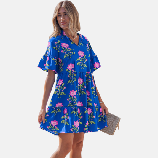 Side profile of the tiered mini dress, illustrating the soft drape of the cotton-viscose fabric and the feminine movement of the flared sleeves.