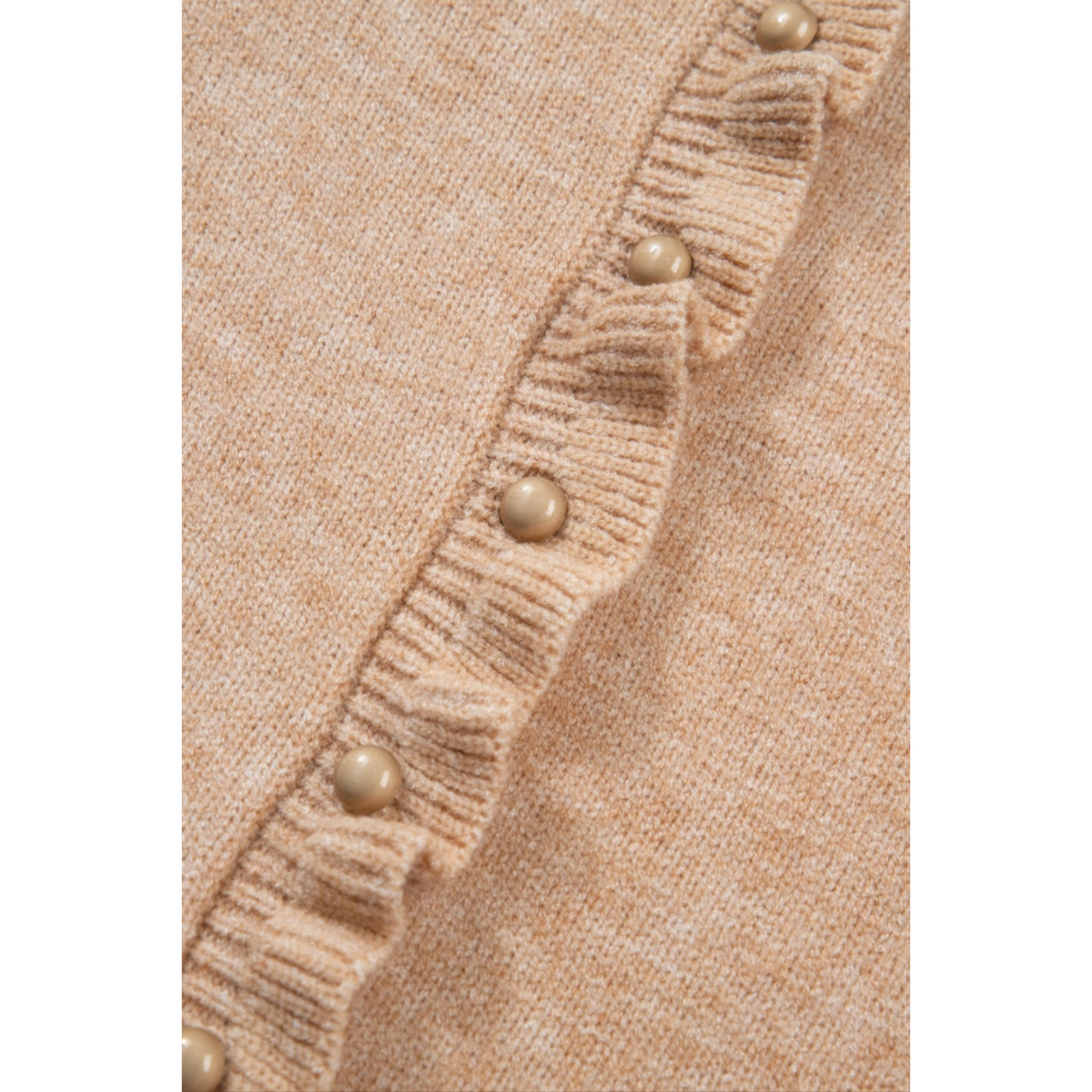 Close-up of a beige cardigan with pearl buttons on a white background.