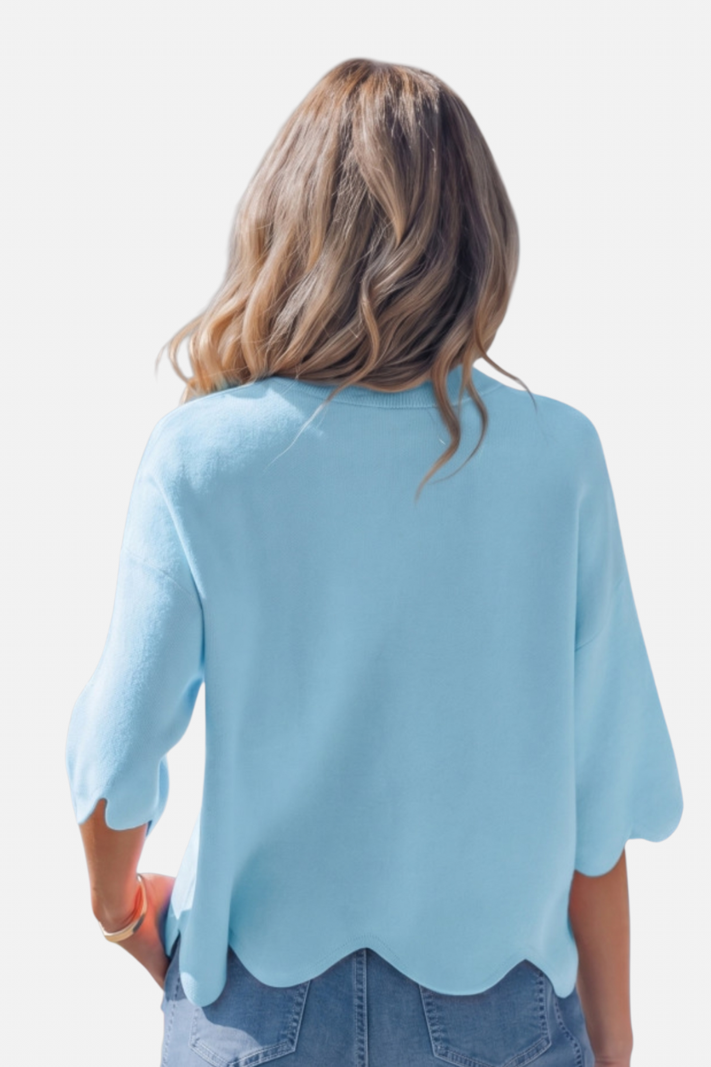 Woman wearing a light blue scalloped hem top on a white background