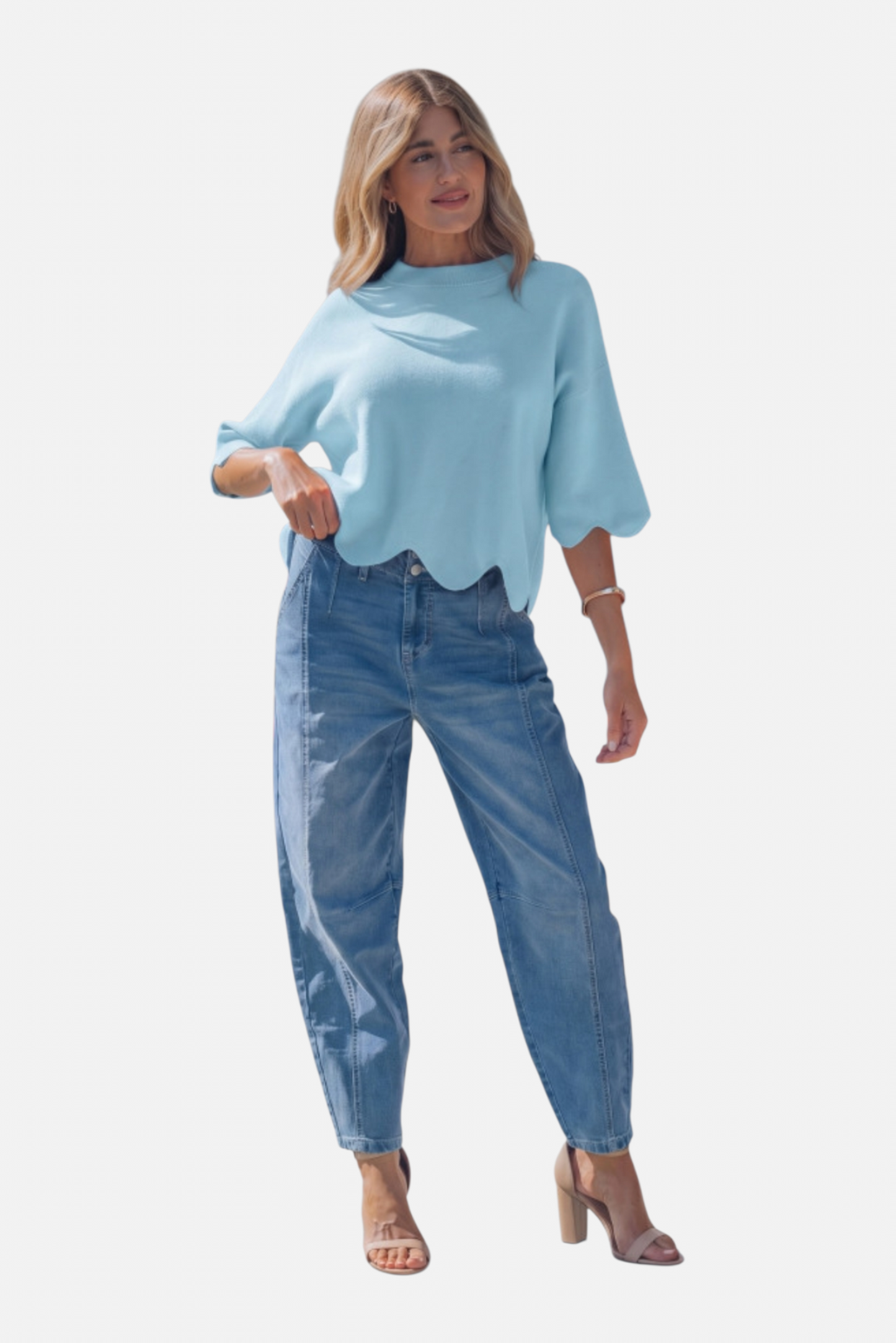 Woman wearing a light blue sweater and jeans on a white background