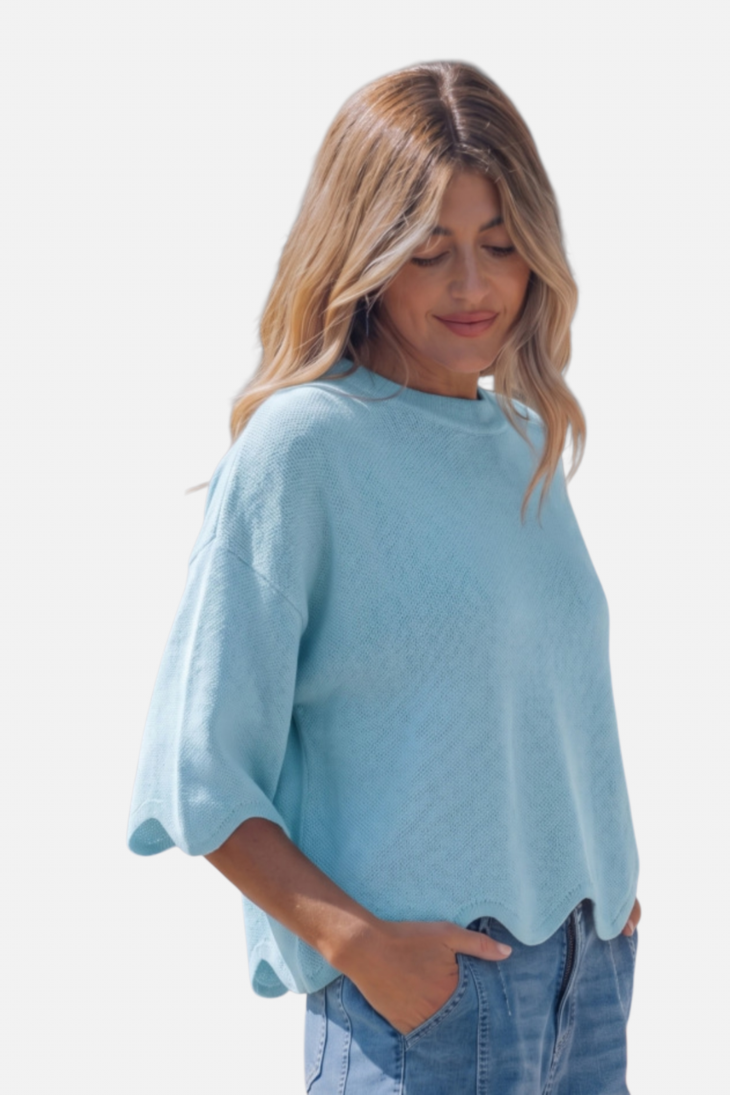 Woman wearing a light blue sweater and jeans on a white background