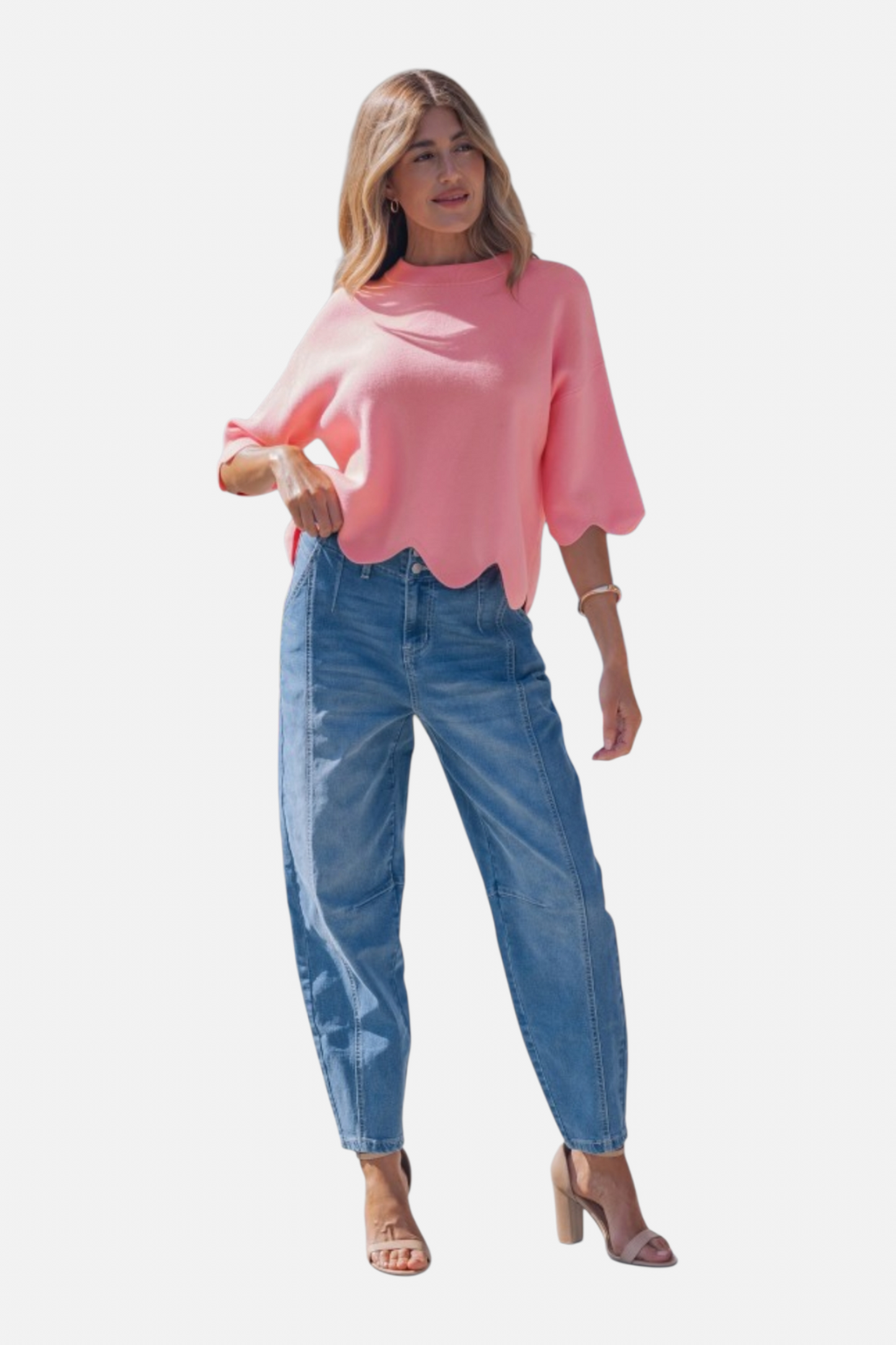 Woman wearing a pink sweater and blue jeans on a white background
