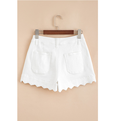 White shorts on a hanger against a beige background