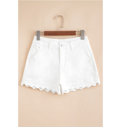 White shorts on a hanger against a beige background