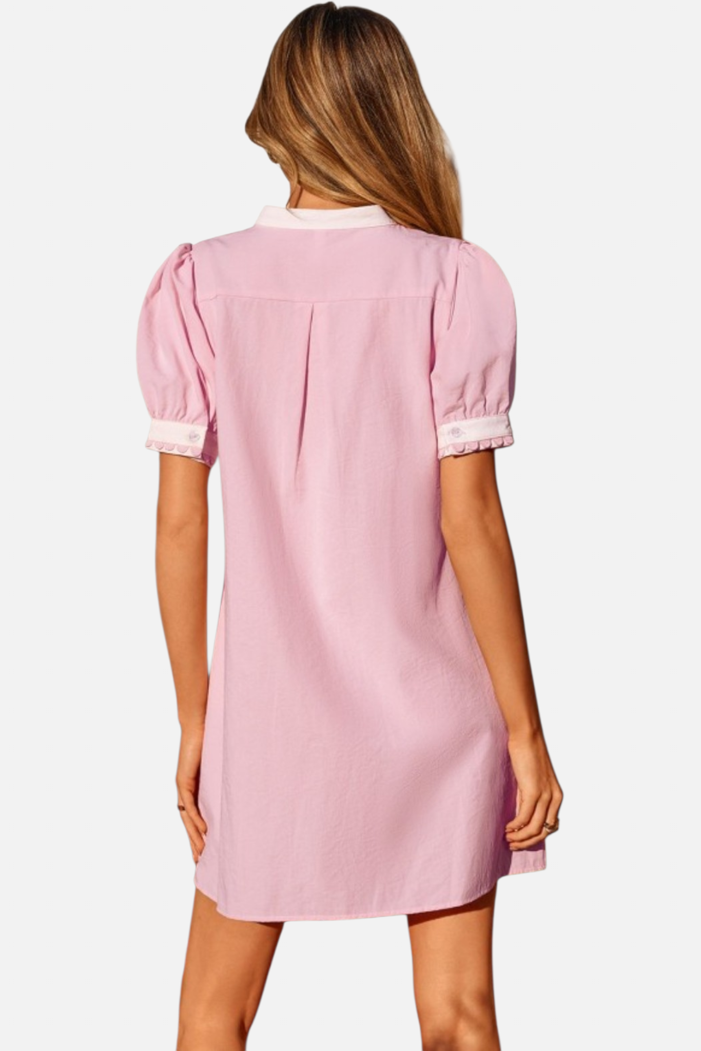 Woman wearing a pink dress with puffed sleeves on a white background