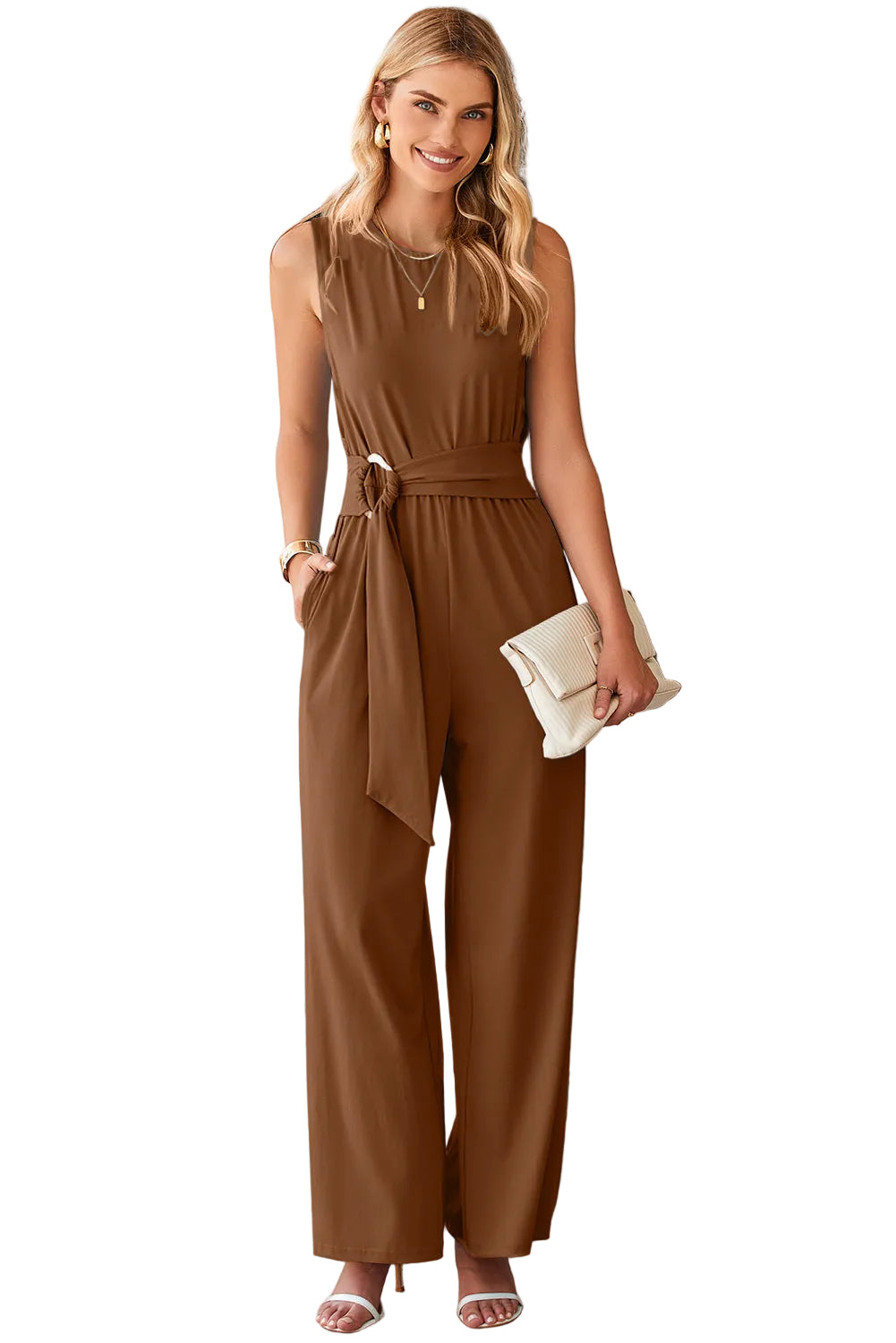 Woman wearing a brown jumpsuit with a belt standing against a white background