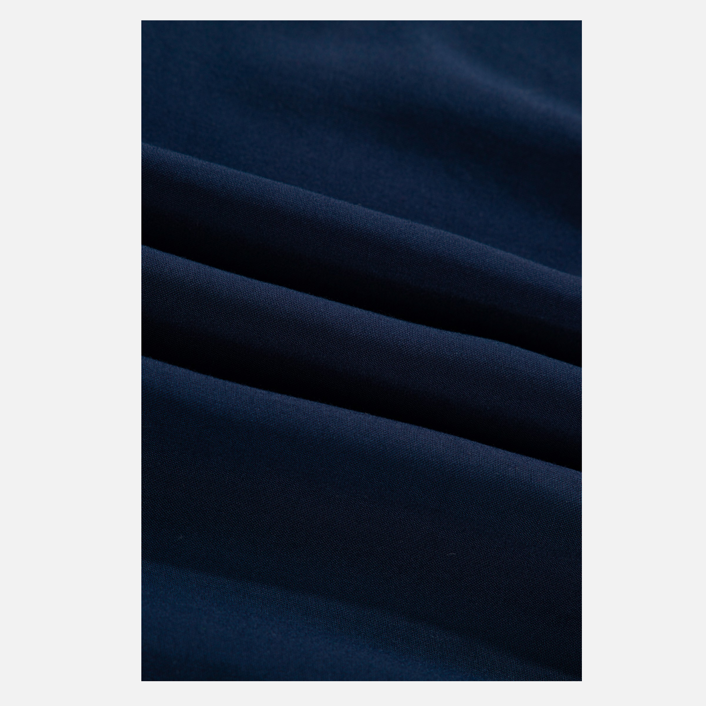 A close-up shot of the high-quality 100% viscose navy blue fabric, highlighting the fine weave and soft, breezy texture of the dress.