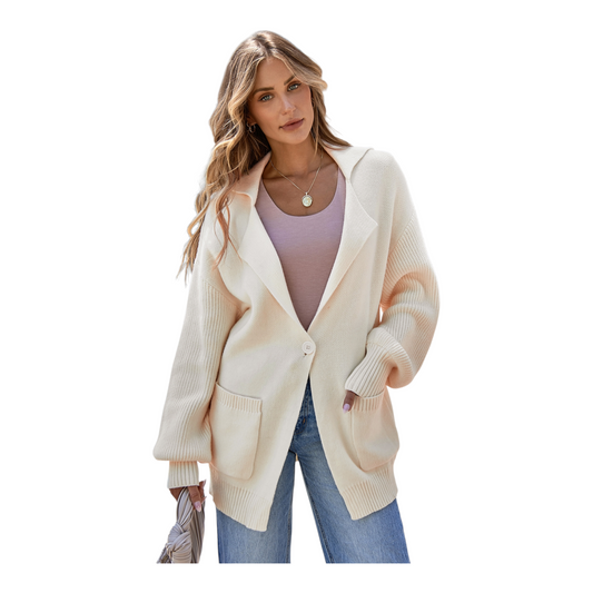 Woman wearing a cream cardigan over a purple top and blue jeans on a white background