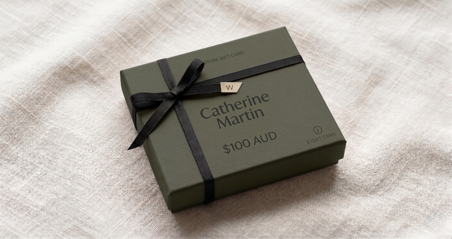 Green gift card box with black ribbon on a textured surface