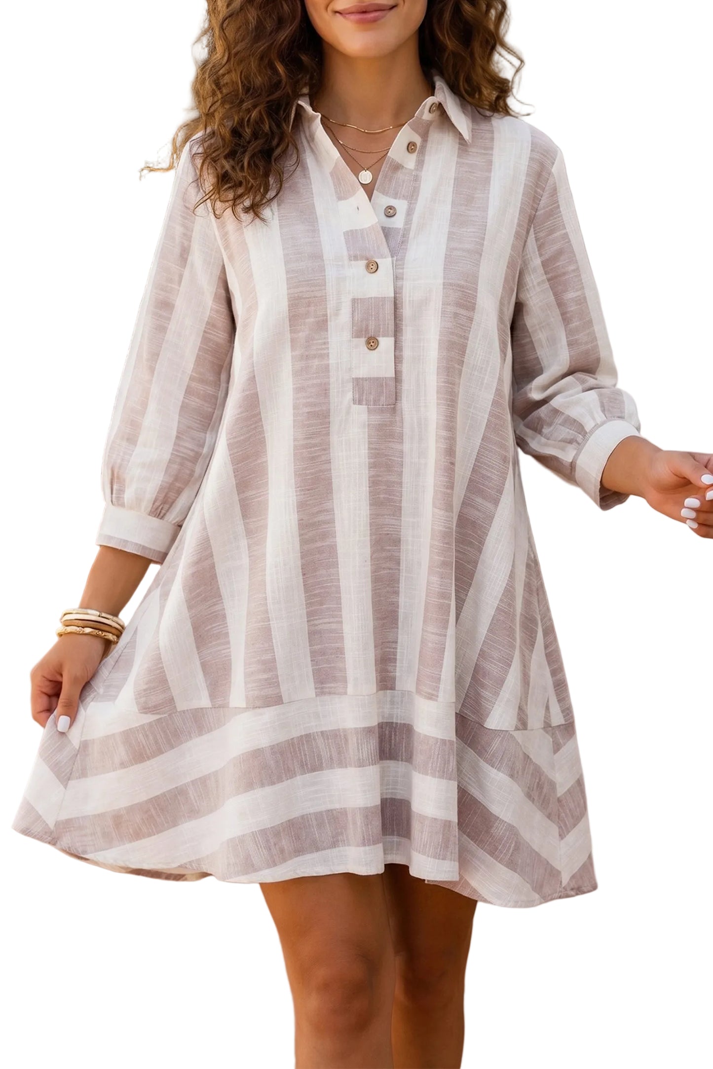 A woman wearing a loose, long-sleeve striped shirt dress in beige and white, standing in against a white background