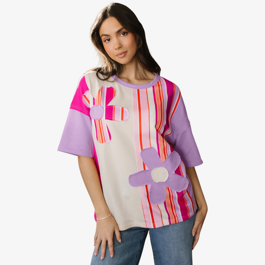 Woman wearing a colorful shirt with floral designs on a white background