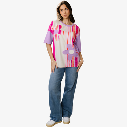 Woman wearing a colorful abstract-patterned shirt and jeans on a white background
