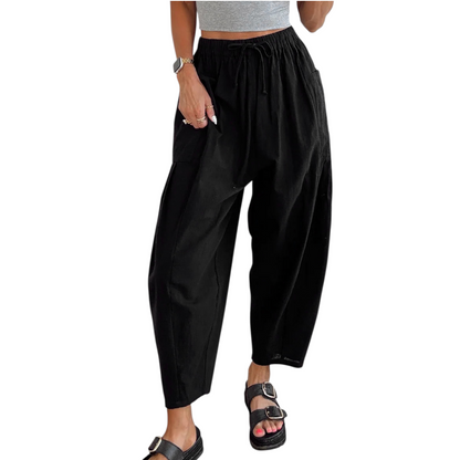 Person wearing black wide-leg pants on a white background