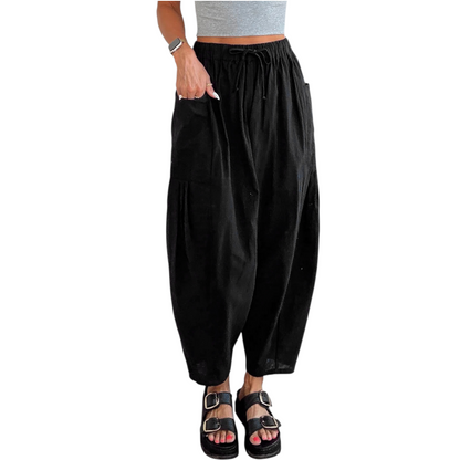 Black harem pants worn by a person on a white background