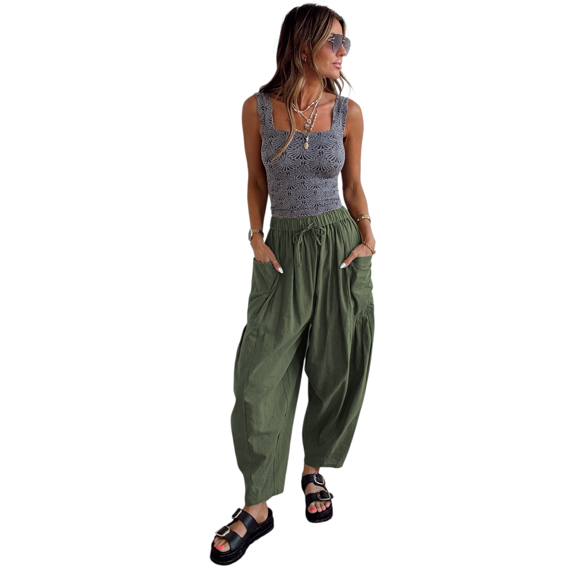 Woman wearing a sleeveless top and green wide-leg pants on a white background