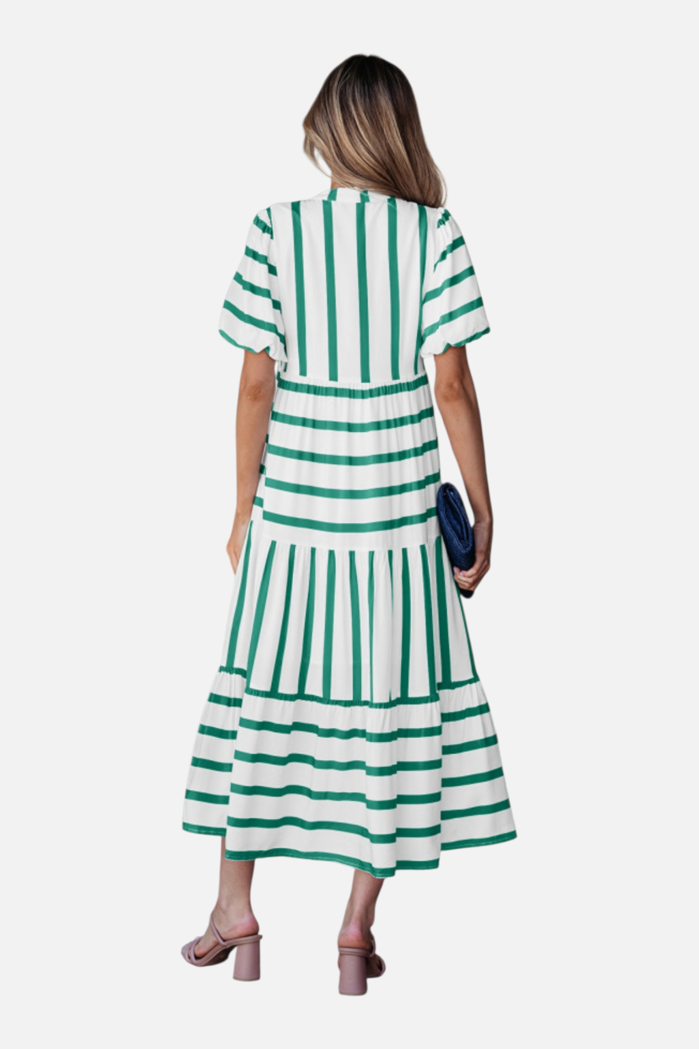 Rear view of a model showcasing the green striped midi dress, featuring a notched V-neckline with blue ricrac trim, puff sleeves, and a tiered skirt in a vacation-ready 100% viscose fabric.
